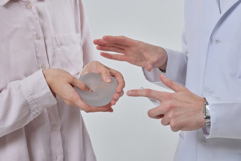 patient holding silicone implant while talking to doctor