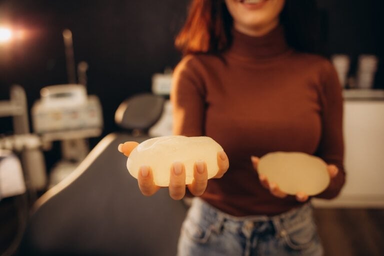 female hand squeezing breast implants