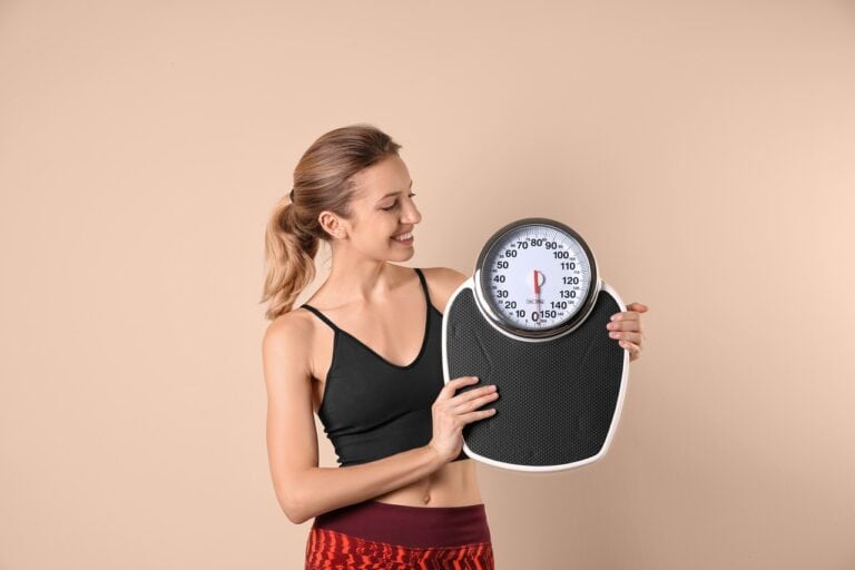 young beautiful woman holding weighing scale